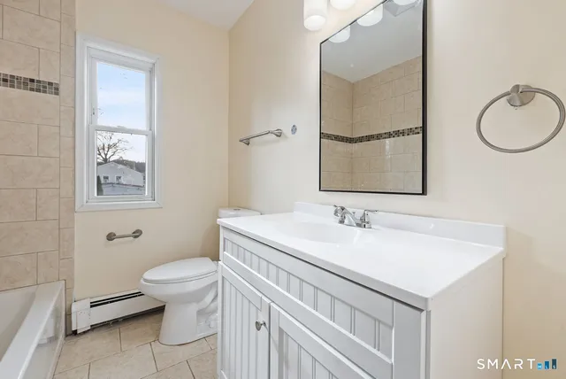 a bathroom with a sink toilet and mirror