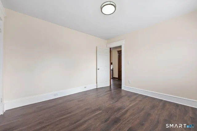 a view of an empty room with wooden floor