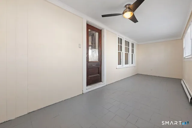 an empty room with windows and fan