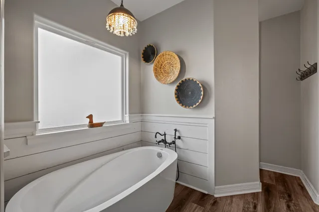 a bathroom with a bathtub and a window