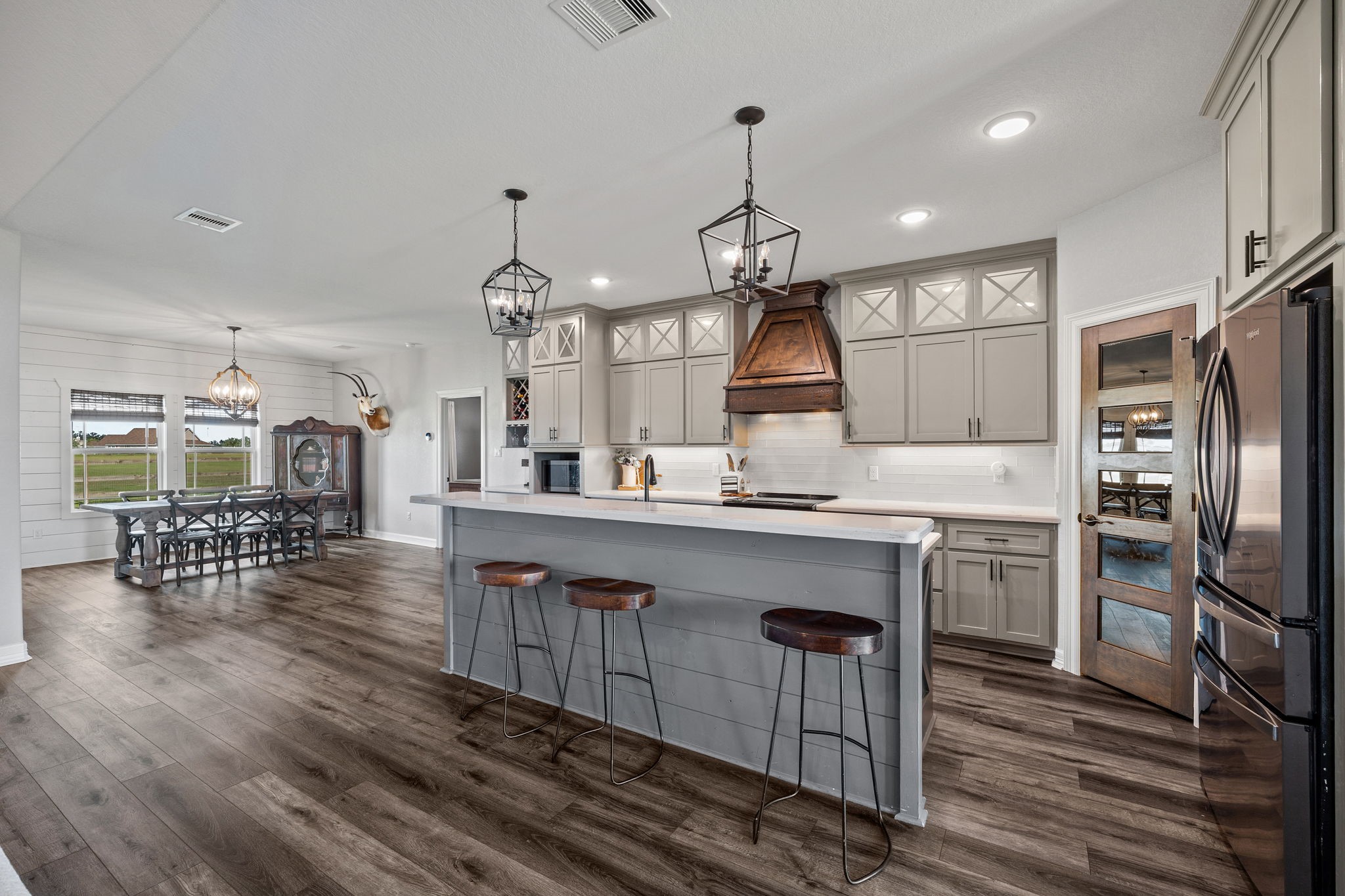 756 Angus Trail Angleton, TX 77515 - Photo 7 of 39 a kitchen with stainless steel appliances a dining table chairs stove and refrigerator