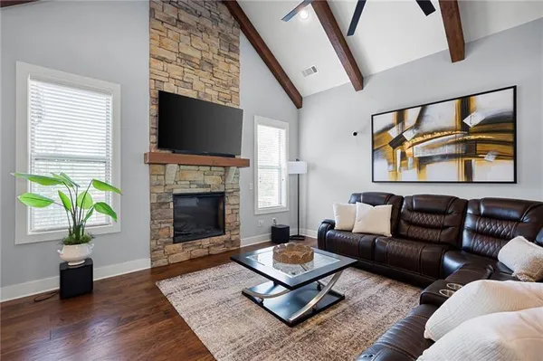 a living room with furniture a flat screen tv and a fireplace