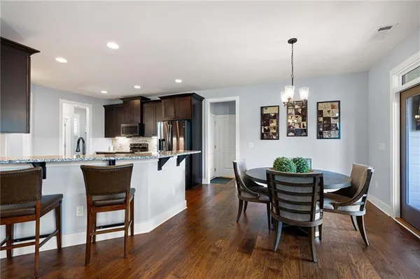 a view of a dining room and livingroom with furniture wooden floor a chandelier