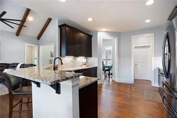 a kitchen with stainless steel appliances granite countertop a sink a stove and a refrigerator