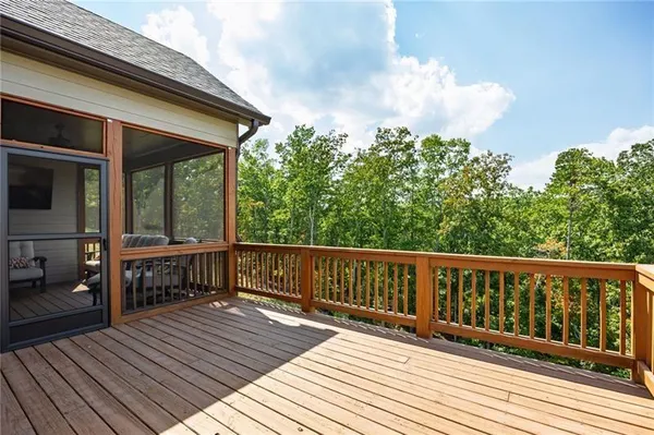 a balcony with wooden floor table and chairs