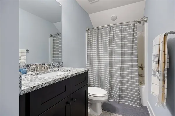 a bathroom with a granite countertop toilet sink and mirror