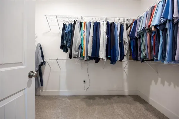 a view of walk in closet with clothes