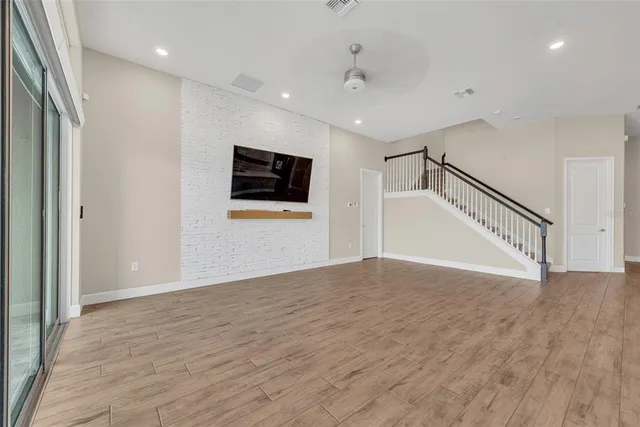 a view of a livingroom with wooden floor and a ceiling fan