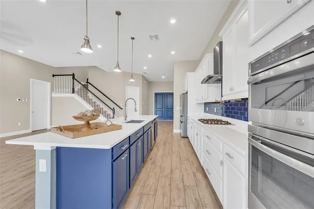 a kitchen with kitchen island a sink a counter top space appliances and a living room view