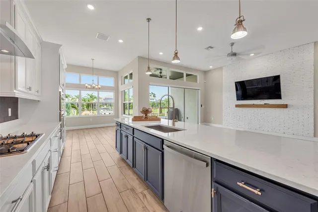 a kitchen with kitchen island a large counter top space a sink stainless steel appliances and cabinets