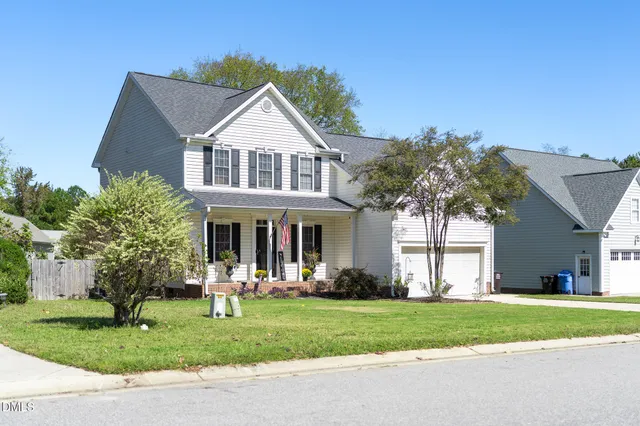 a front view of a house with a yard and trees