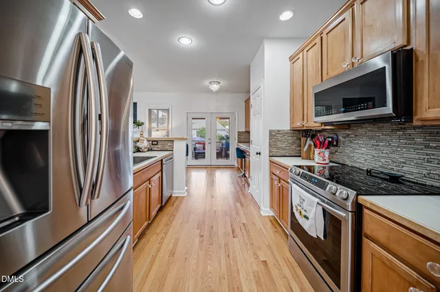 a kitchen with stainless steel appliances granite countertop a refrigerator a stove top oven a sink and dishwasher