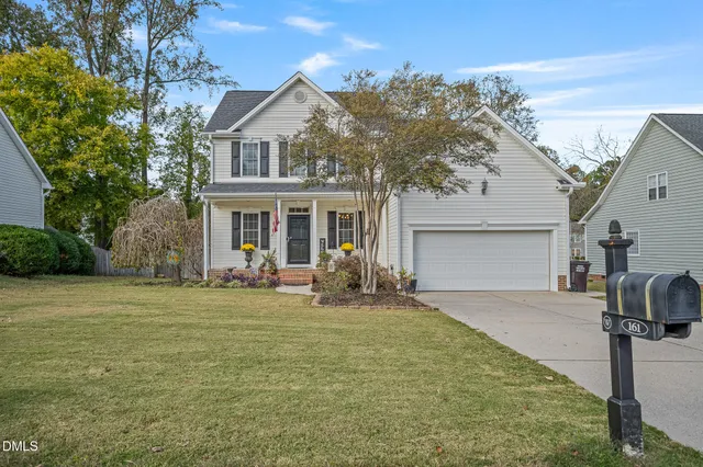 a living room with furniture a flat screen tv and a chandelier