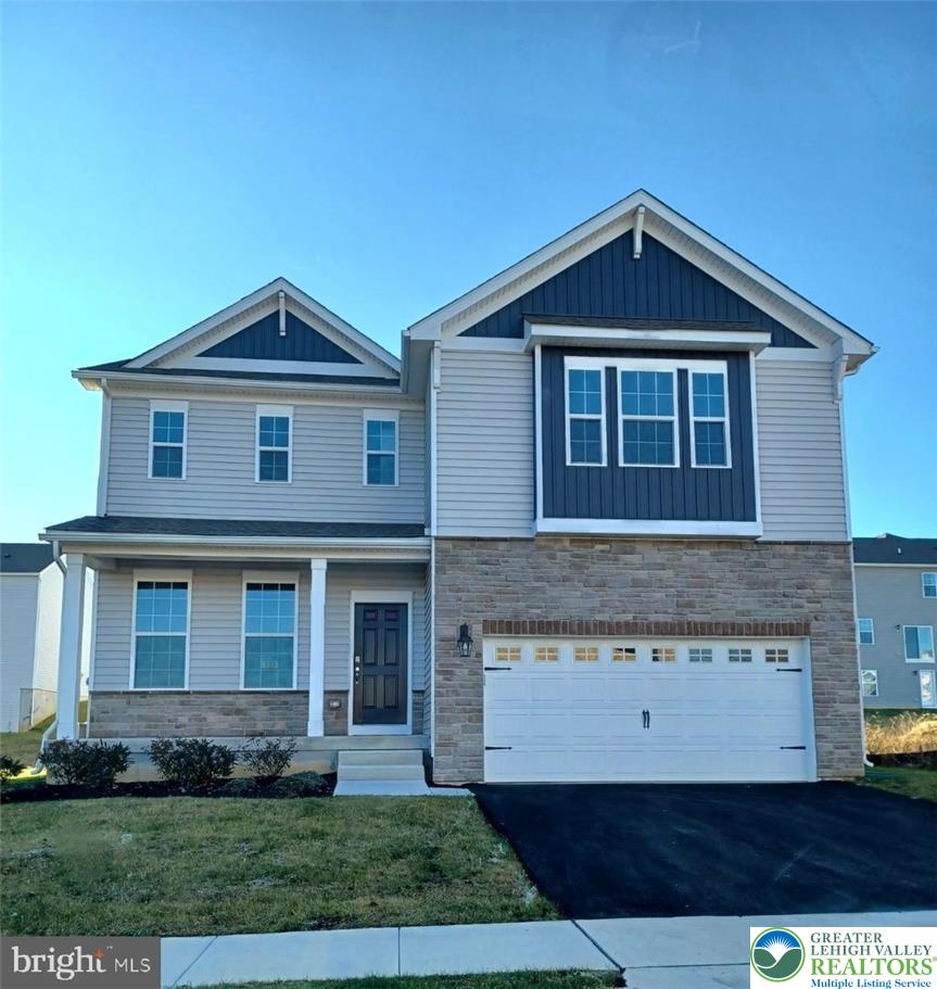 115 Winding Road Easton, PA 18040 - Photo 2 of 24 A well-maintained facade features a mix of siding and stone, complemented by a neatly paved driveway leading to the garage.
