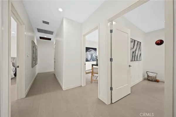 a view of a hallway with refrigerator and cabinet