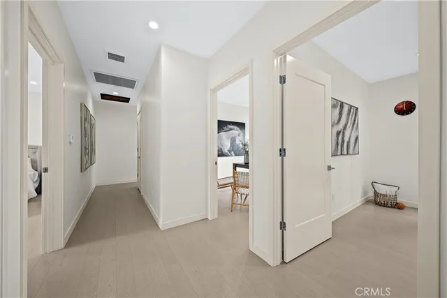 a view of a hallway with refrigerator and cabinet
