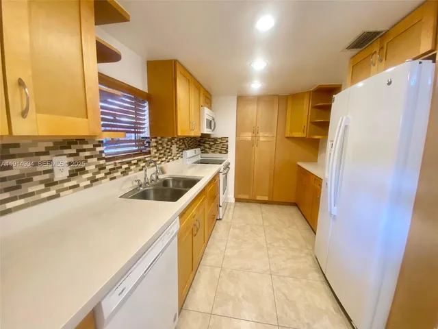 a kitchen with a sink and a refrigerator