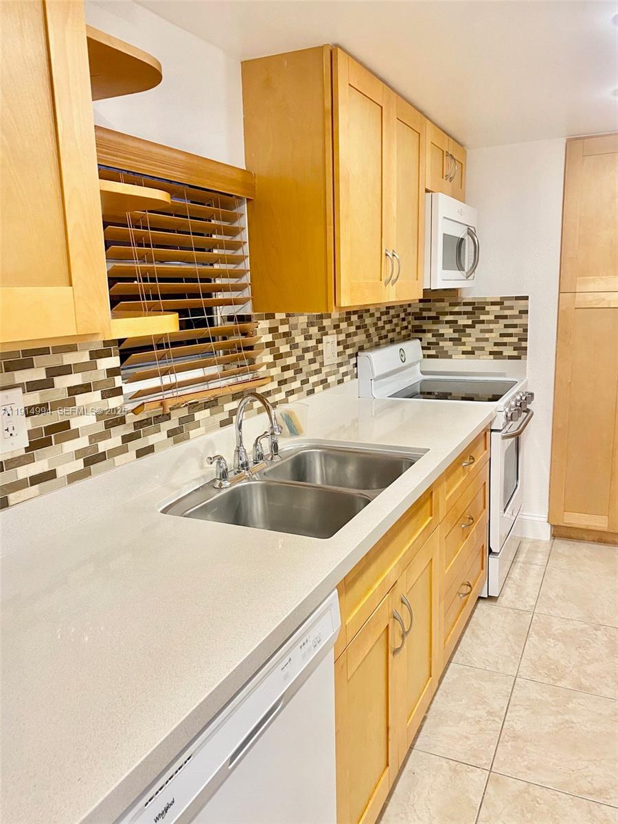 6568 Southwest 41st Place, Unit 151 Davie, FL 33314 - Photo 14 of 65 a kitchen with stainless steel appliances a sink and a stove