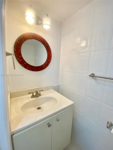 a bathroom with a granite countertop sink and mirror