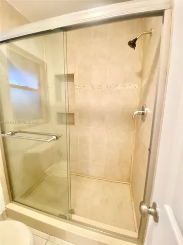 a bathroom with a granite countertop sink toilet a mirror and shower