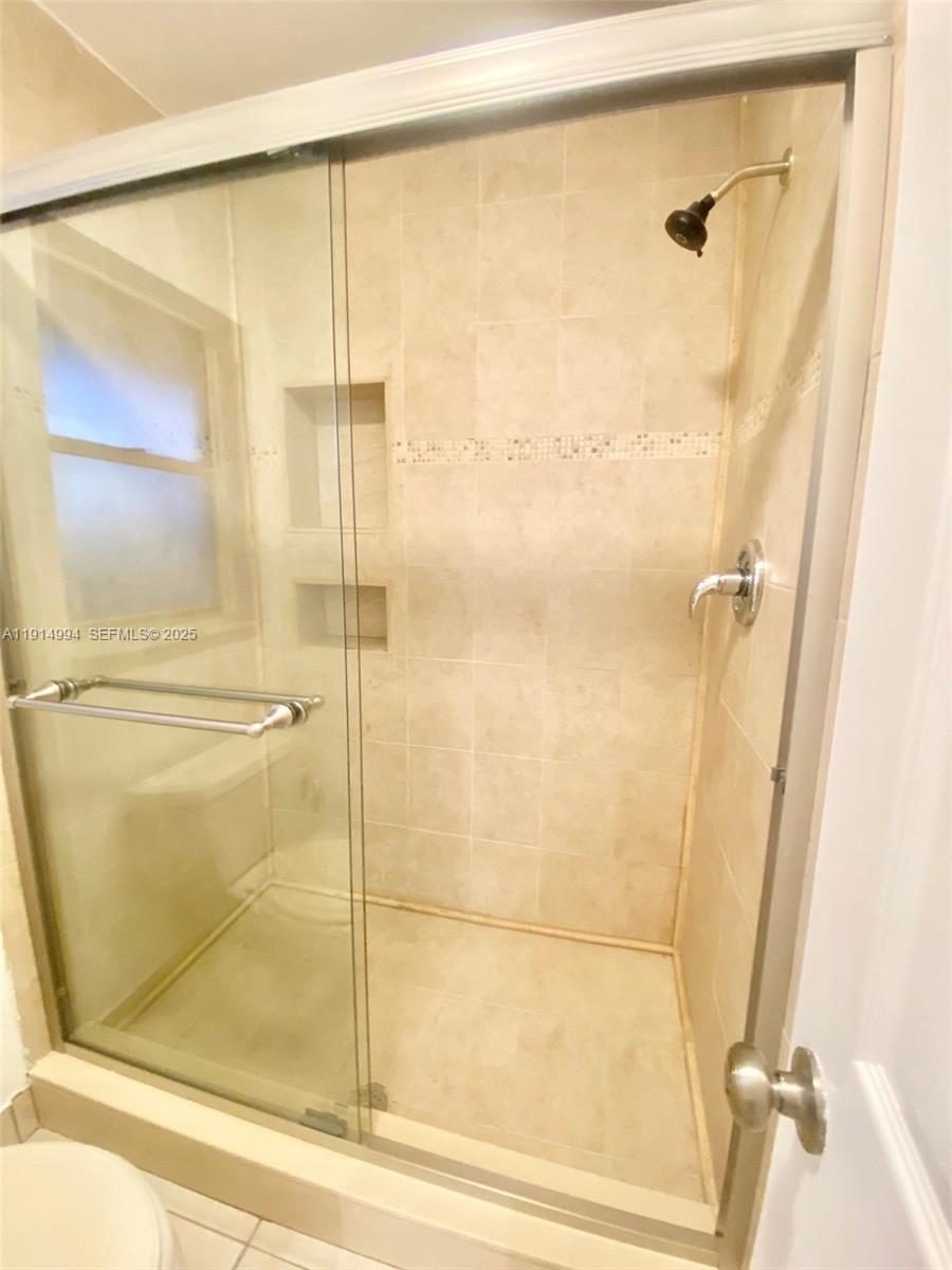 6568 Southwest 41st Place, Unit 151 Davie, FL 33314 - Photo 31 of 65 a bathroom with a glass shower door