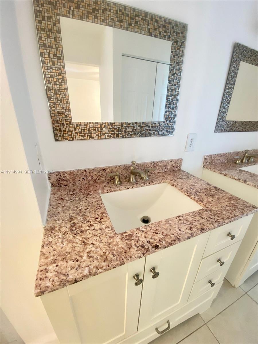 6568 Southwest 41st Place, Unit 151 Davie, FL 33314 - Photo 35 of 65 a bathroom with a granite countertop sink and mirror