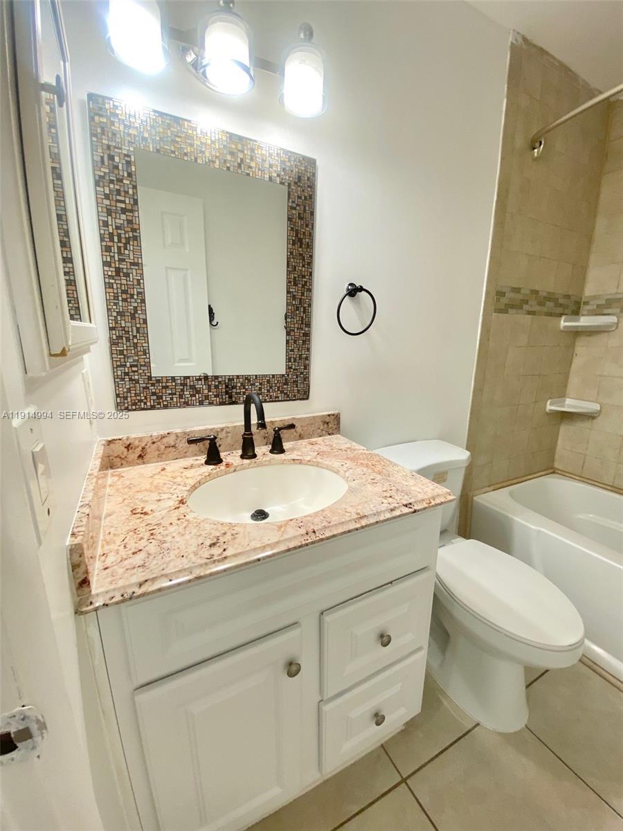 6568 Southwest 41st Place, Unit 151 Davie, FL 33314 - Photo 40 of 65 a bathroom with a granite countertop sink a toilet and a mirror