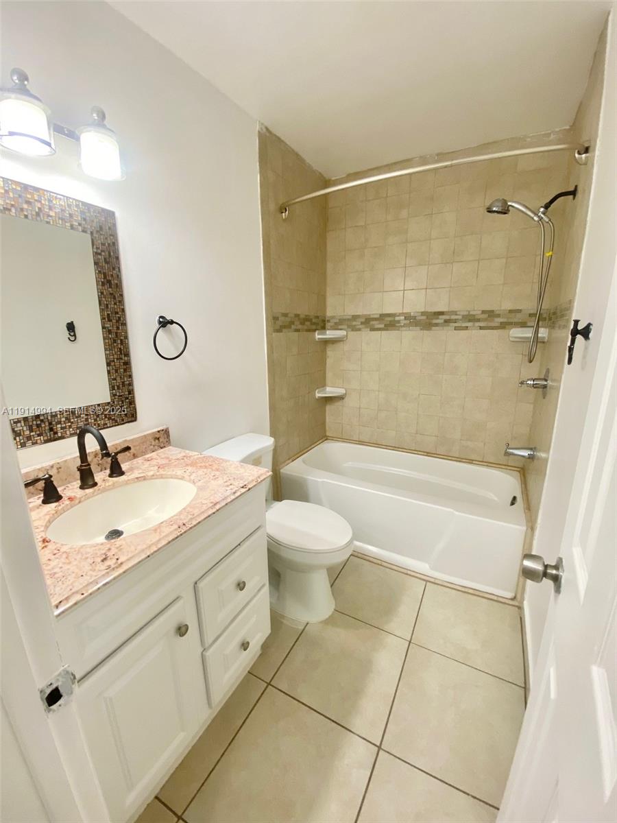 6568 Southwest 41st Place, Unit 151 Davie, FL 33314 - Photo 42 of 65 a bathroom with a granite countertop sink toilet a mirror and shower