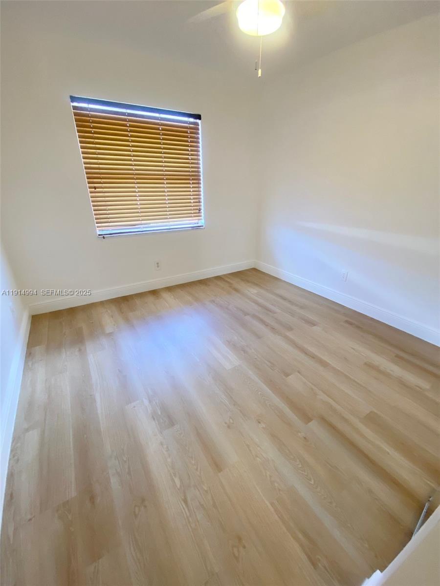 6568 Southwest 41st Place, Unit 151 Davie, FL 33314 - Photo 46 of 65 a view of an empty room with wooden floor and a window
