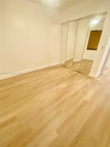 a view of empty room with wooden floor and large windows
