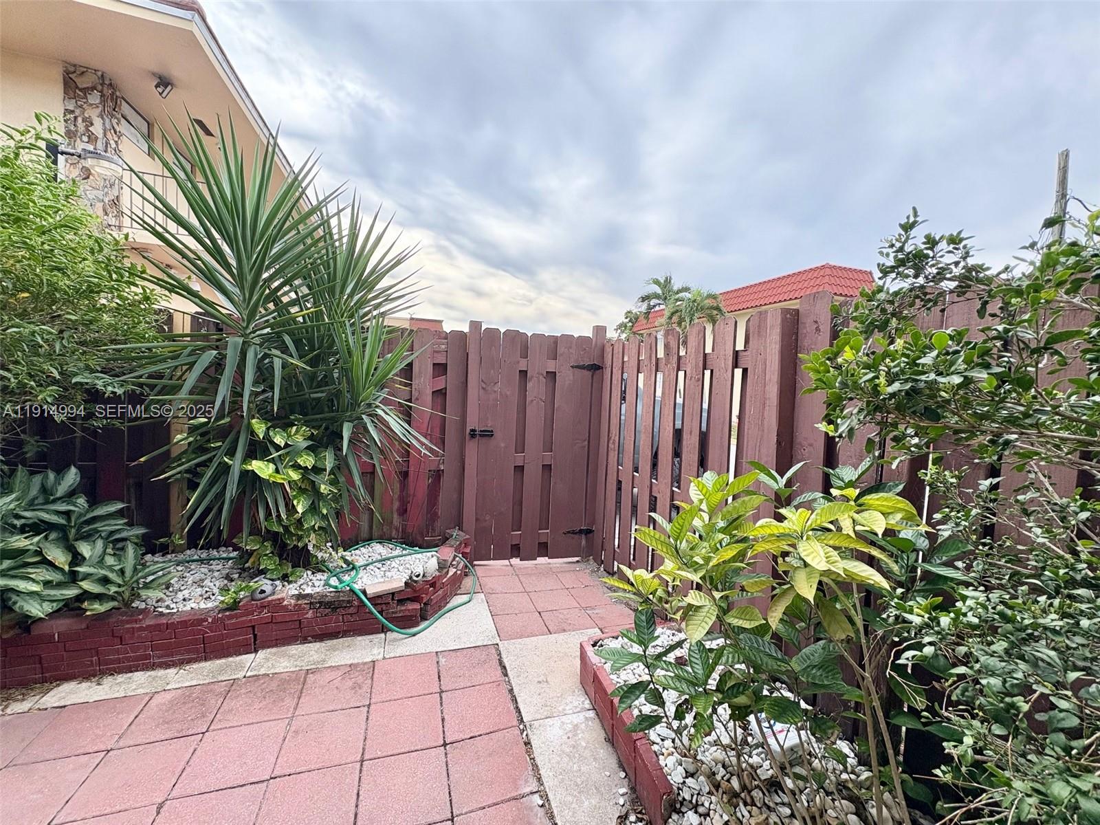 6568 Southwest 41st Place, Unit 151 Davie, FL 33314 - Photo 59 of 65 a view of backyard with potted plants and a large tree