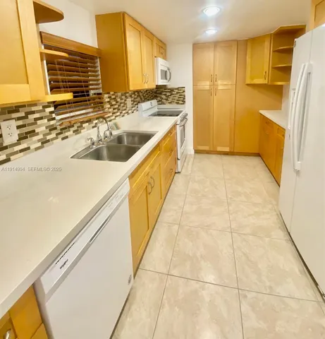 a view of a kitchen with stainless steel appliances granite countertop a sink and cabinets