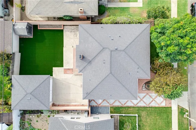 an aerial view of a house with garden space and a street view