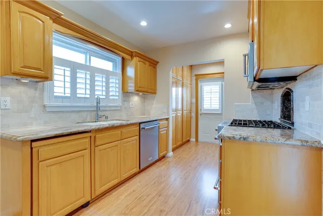 a kitchen with granite countertop wooden floors and white cabinets