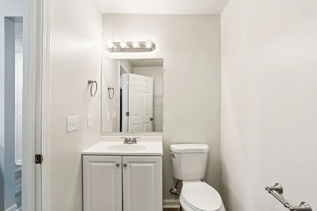 a bathroom with a toilet a sink and mirror