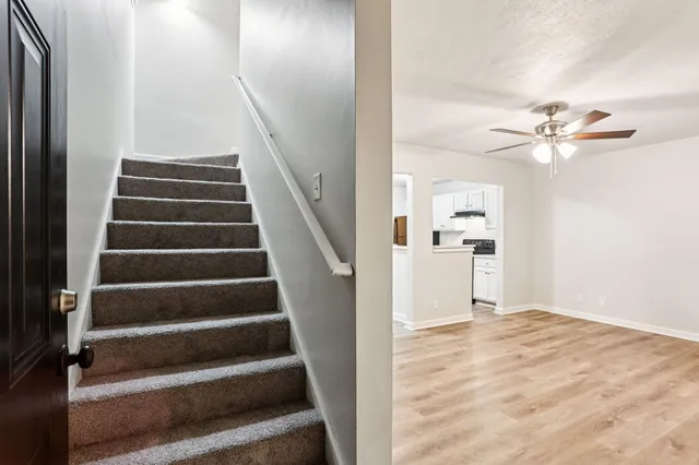 a view of an entryway with wooden floor and a ceiling fan