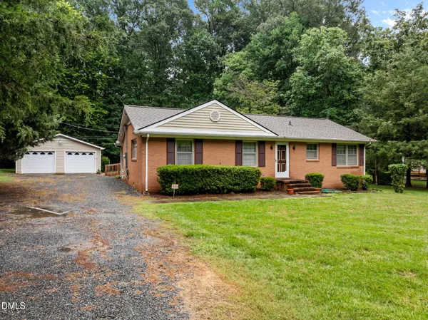 a front view of a house with a yard and trees