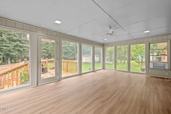 a view of an empty room with wooden floor and a floor to ceiling window