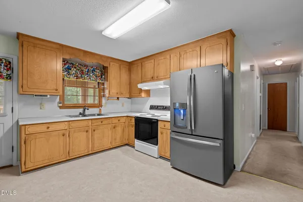 a kitchen with stainless steel appliances granite countertop a refrigerator and a sink