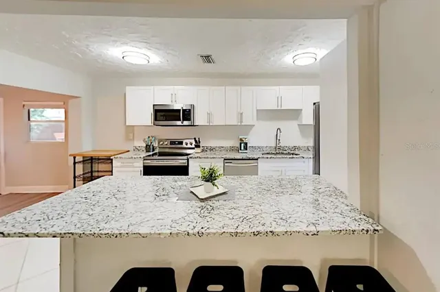 a kitchen with granite countertop counter top space cabinets and stainless steel appliances