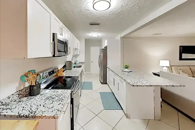a kitchen with stainless steel appliances granite countertop a sink stove and cabinets