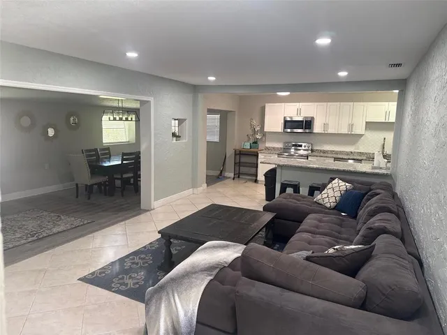 a living room with furniture wooden floor and a view of kitchen