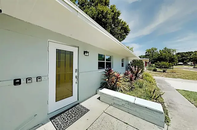 a view of a entryway door and potted plants