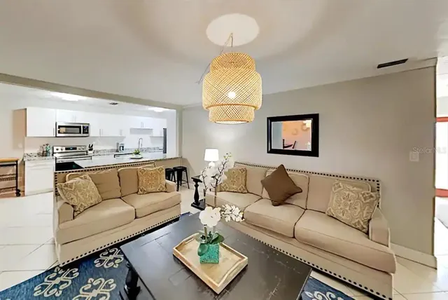 a living room with furniture and a chandelier