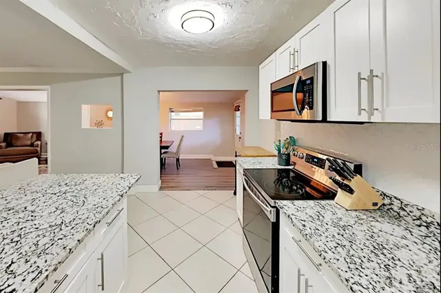 a kitchen with a sink a stove and cabinets