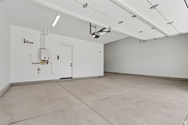 2862 South Mountain Rnch Road Cedar City, UT 84720 - Photo 43 of 64 Spacious garage with concrete flooring, tankless water heater, interior access door, and overhead lighting