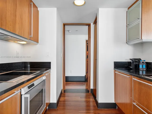 a kitchen with stainless steel appliances granite countertop a refrigerator and a stove top oven