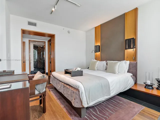 a bedroom with a bed and a dresser next to a window