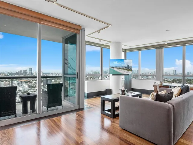 a living room with furniture stove and kitchen view