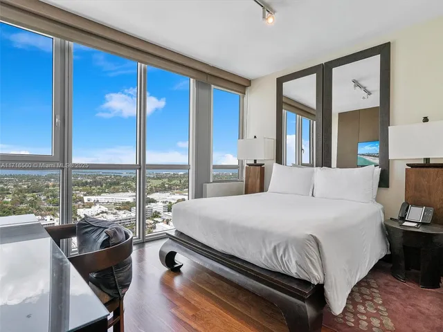 a bedroom with a large bed and a large window